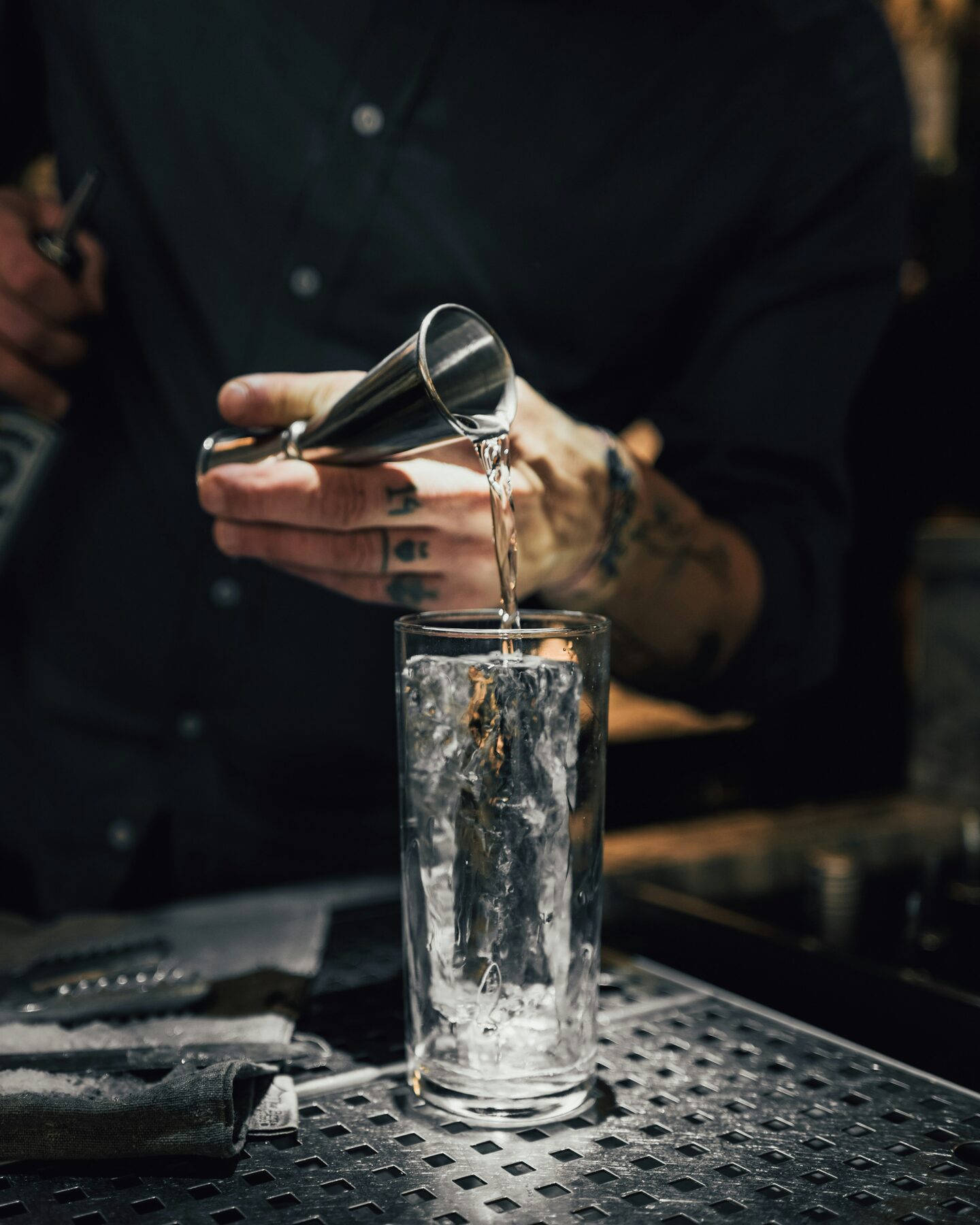 Bartender pouring a drink over ice