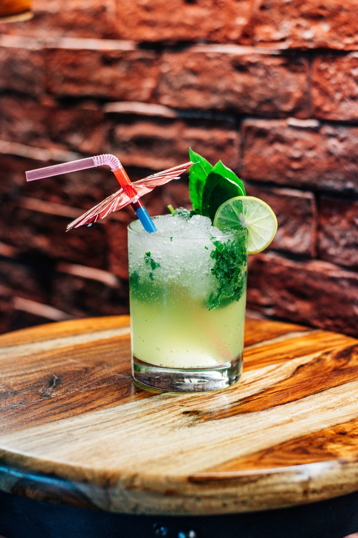 Green mocktail with lime and mint garnish on a wooden table