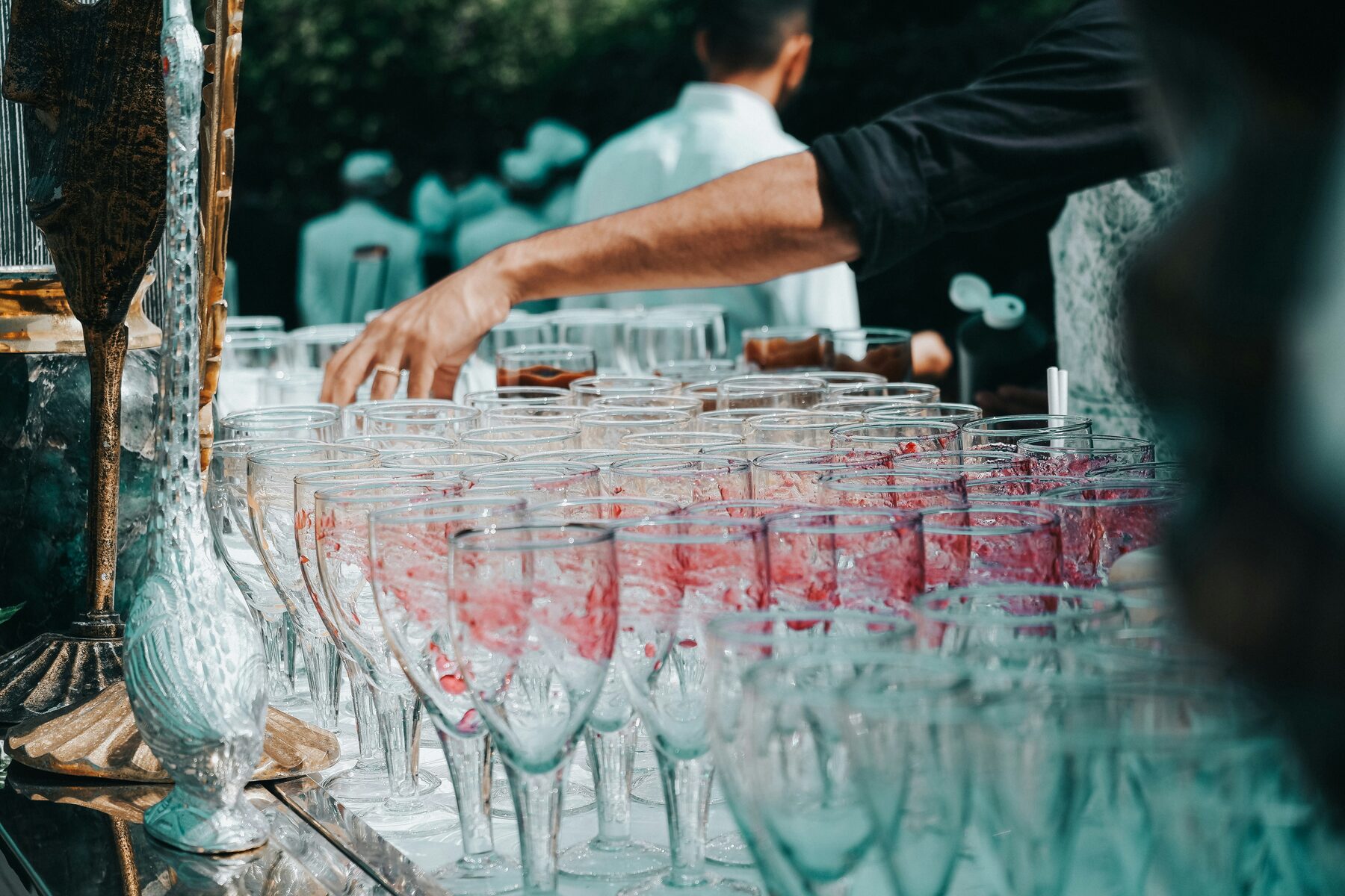 Bartender setting up rows of glassware at an event